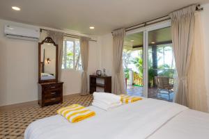 Postel nebo postele na pokoji v ubytování The Rose Goa Beach Resort