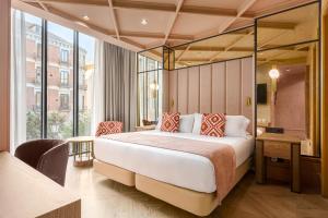 a bedroom with a large bed and a large window at Room Mate Leo, Granada in Granada