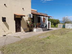 a house with a porch with a chair in front of it at Villa S'Oliariu in Martis