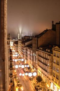 a city street at night with cars and buildings at AtuaireHome Hostal en el centro de Burgos in Burgos