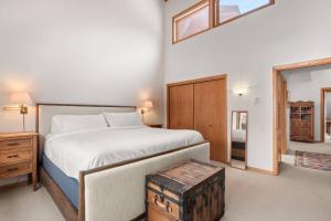 a bedroom with a large bed with a wooden trunk next to it at Ridge 27 in Snowmass Village
