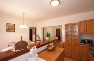 a kitchen with wooden cabinets and a counter top at Holiday Apartment Ori in Nedeščina