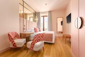 a room with a bed and a table and chairs at Room Mate Leo, Granada in Granada