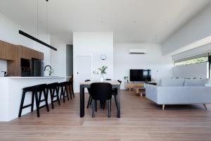 a kitchen and living room with a table and chairs at Modern Beaconsfield Retreat with Town Views in Beaconsfield