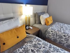 a small room with two beds and a lamp at Xixi Cama Bed & Breakfast in Bombardeira