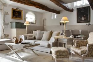 een woonkamer met een bank, stoelen en een tafel bij Le Mas De La Rose - Teritoria in Orgon