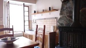 eine Küche mit einem Holztisch und einem Kamin in der Unterkunft Le Gîte du Rocher - Auzat in Auzat + 7 Fotos