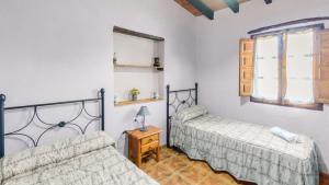 a bedroom with two beds and a table with a lamp at Casa Tobalo Hijo Almachar by Ruralidays in Almáchar +21 photos