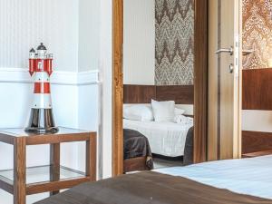 a bedroom with a bed and a red lamp on a table at Holiday Beach Budapest Wellness Hotel with Sauna Park in Budapest