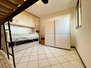 a kitchen with a refrigerator and a tiled floor at Villa Giulia in Is Molas 
