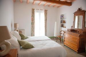 a bedroom with two beds and a dresser and a window at La Maison de Famille in Aigues-Mortes