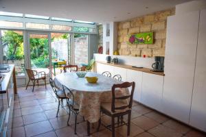 a kitchen and dining room with a table and chairs at La Maison de Famille in Aigues-Mortes