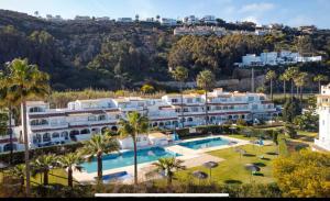 an image of a resort with a swimming pool and palm trees at Casa Playa Paraiso Manilva in Manilva