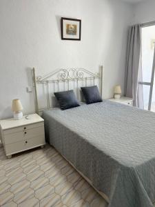 a bedroom with a bed with blue pillows on it at Casa Playa Paraiso Manilva in Manilva