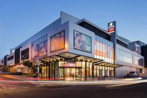 a building with a ceyes sign on the side of a street at 3-Bedroom House near Train Station with Netflix in Revesby