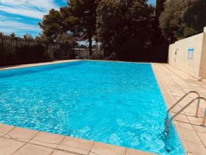 a swimming pool with blue water in a yard at Le Balcon de l'Oliveraie, Piscine, Parking, Calme in Grabels