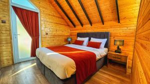 a bedroom with a bed in a wooden cabin at Luna Home Club in Samandağı
