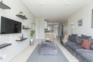 a living room with a couch and a tv at Casa Bella in Summerstrand