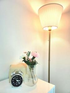 a lamp and a vase with flowers and a clock at Raon Seoul in Seoul +24 photos