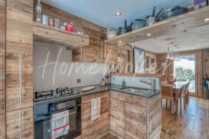 a kitchen with wooden walls and a sink and a stove at Chalet Hermine in Megève +16 photos