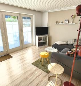 フリードリッヒシュコオクにあるFerienwohnung Deichkate - Auszeit an der Nordseeのソファとテレビのあるリビングルーム