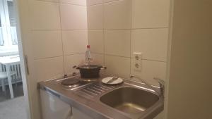 a kitchen with a sink and a pot on a stove at Gästepension - Elsterland am Sport- und Freizeitpark in Elster