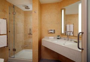 a bathroom with a tub and a sink and a shower at Malta Marriott Resort & Spa in St. Julianʼs