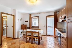 a kitchen and dining room with a table and chairs at Residence Malibu Appartamento 5 in Falcade