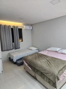 ein Zimmer mit zwei Betten und einem Fenster in der Unterkunft Casa em Jacumã in Conde