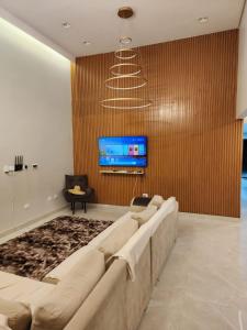 ein Wohnzimmer mit einem Sofa und einem Fernseher an der Wand in der Unterkunft Casa em Jacumã in Conde + 18 Fotos