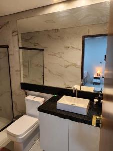 ein Badezimmer mit Toilette, Waschbecken und Spiegel in der Unterkunft Casa em Jacumã in Conde