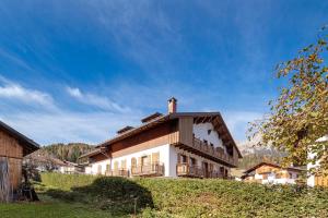 a house on a hill with a blue sky at Residence Malibu Appartamento 2 in Falcade