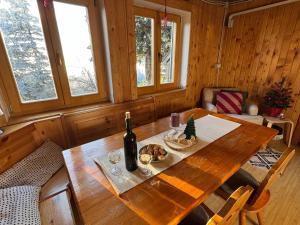 - une table en bois avec une bouteille de vin et du pain dans l'établissement Chalet Košutnik Velika planina, à Kamniška Bistrica