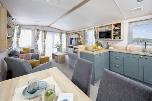 a kitchen and living room with a table and chairs at Lochgilphead Caravan Park in Lochgilphead