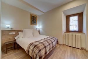 a small bedroom with a bed and a window at Casa Jansú in Escuñau