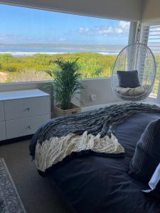 a bedroom with a bed and a large window at Whalestail in Witsand