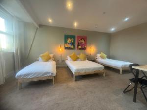 ニューカッスル・アポン・タインにあるWasters Arts Bar & Hotel, Contractor's Welcomeのベッド2台とテーブルのある部屋