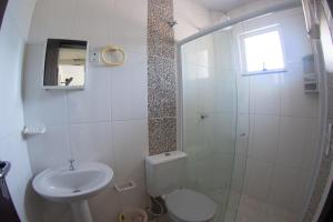 a bathroom with a toilet and a sink and a shower at Residencial Oceano Azul in Itapoa +27 photos