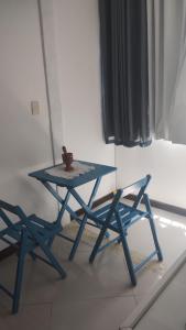 a blue picnic table and two chairs in a room at Loft Geribá in Búzios