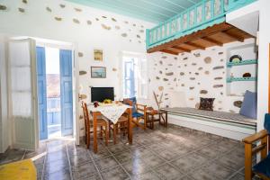 a living room with a table and chairs and a bed at Margarita's Houses in Astypalaia