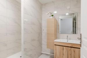 a white bathroom with a sink and a mirror at Le Havre du Bois Coquard - Proche Disney in Chessy +35 photos