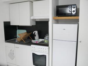 une petite cuisine avec une cuisinière et un micro-ondes dans l'établissement Maison de plein pied à Barcares, au Barcarès