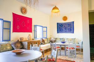 un soggiorno con divano, tavoli e sedie di Mir Dunes&Waves Camp a Mirleft