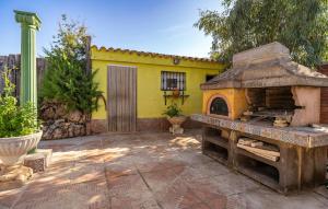 a patio with a yellow house with an outdoor oven at Stunning Home In Chiclana De La Fronter in Chiclana de la Frontera +19 photos