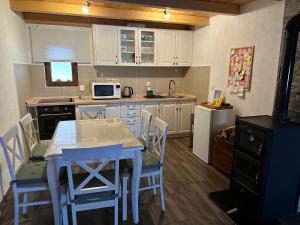 a kitchen with white cabinets and a table and chairs at Vila Gorska in Žabljak