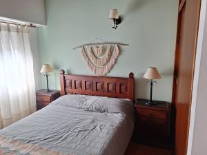 1 dormitorio con 1 cama, 2 mesitas de noche y 2 lámparas en Dúplex con garage, patio y parrilla, en Tandil