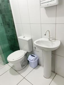 a bathroom with a toilet and a sink at Hospedagem e kitnetes D' Itália in Curitiba