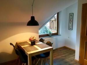 a dining room with a wooden table and a window at Lusht'n apartma in Žirovnica