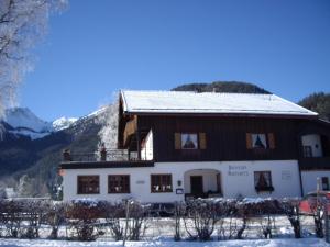 ein großes Haus mit einem schneebedeckten Dach in der Unterkunft Gasthaus Aiplspitz in Bayrischzell