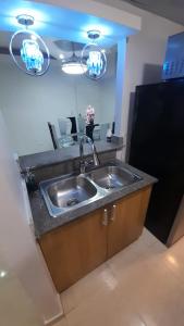 a kitchen with a stainless steel sink and two lights at Palmer in Santiago de los Caballeros +4 photos